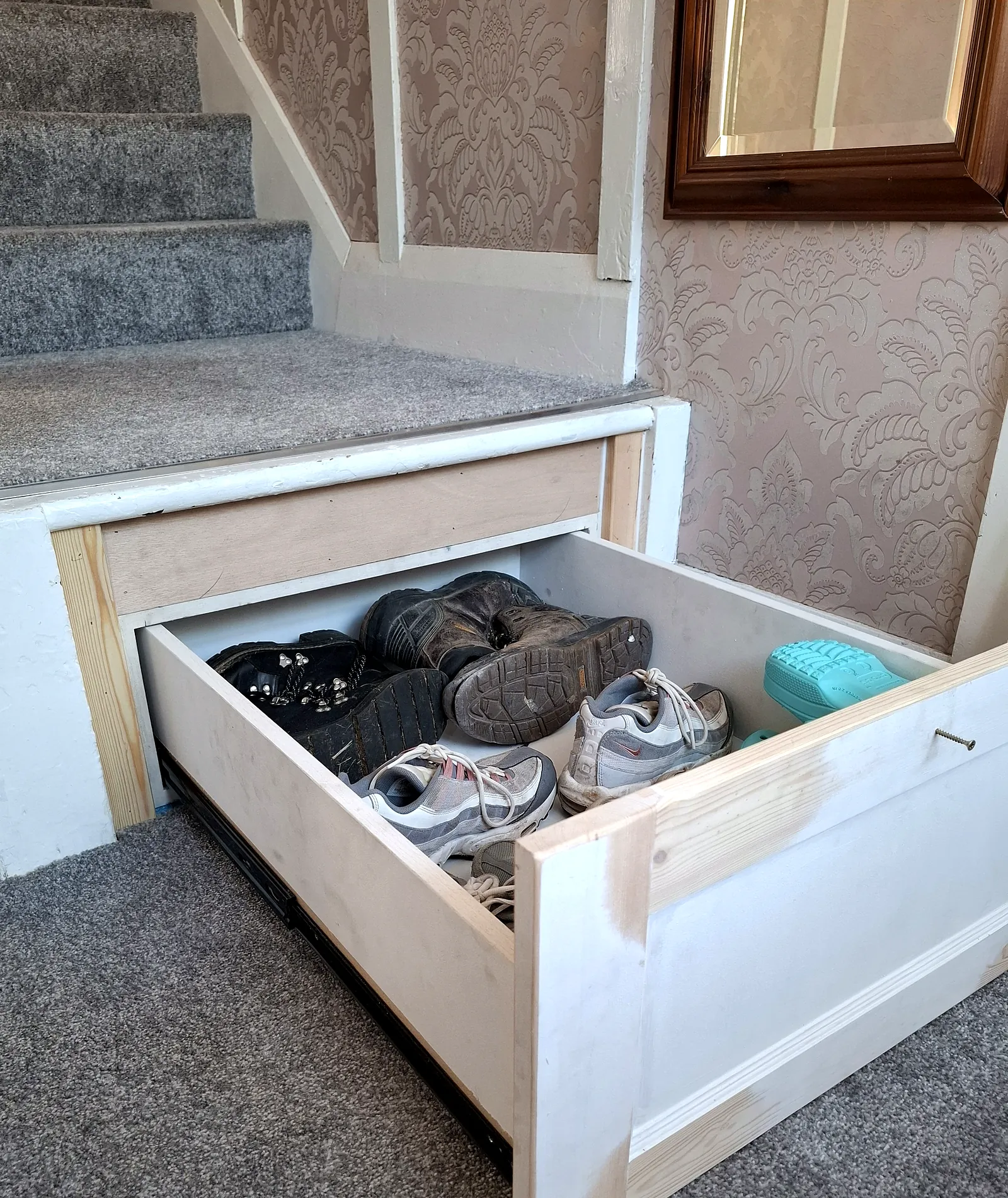Hidden drawer built into the bottom stair, full of shoes