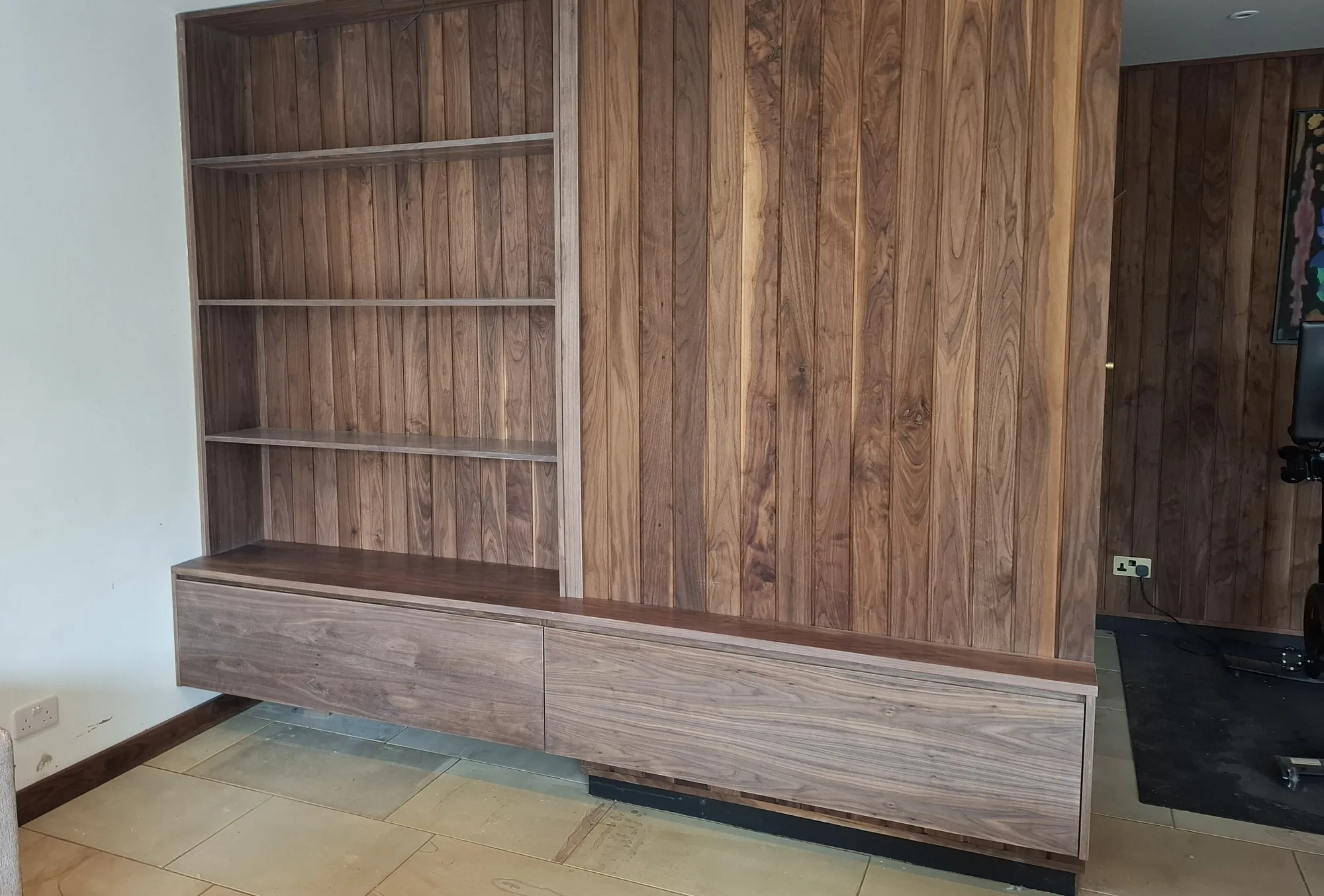 Walnut media wall with open shelving and floating drawers